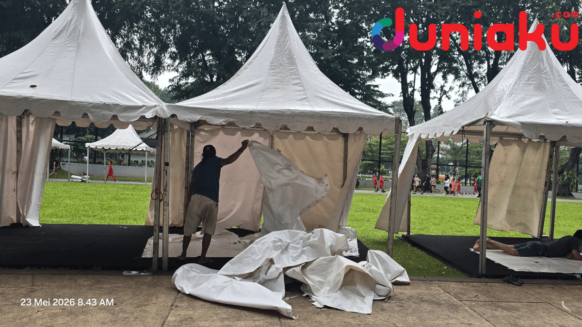 Seorang pekerja membongkar tenda putih di Lapangan Banteng Jakarta setelah acara Djakarta Ennichi dibatalkan pada pagi hari.