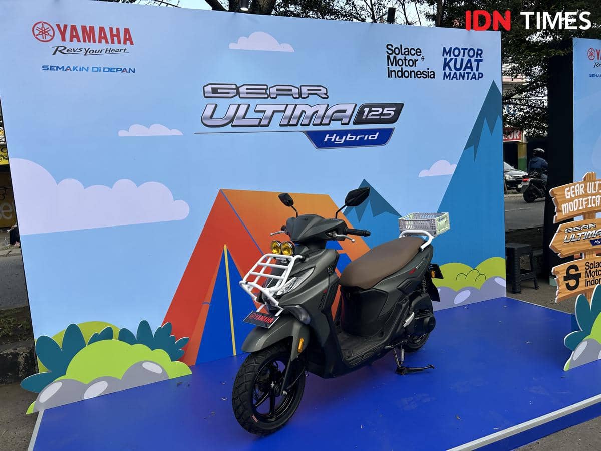 Motor Yamaha Gear Ultima 125 Hybrid hasil modifikasi dipamerkan di atas panggung dengan latar bertema alam dan logo Yamaha.