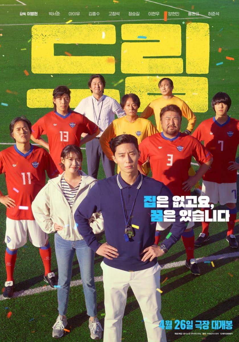 Poster film Dream menampilkan sekelompok pemain sepak bola dengan seragam merah dan pelatih di lapangan hijau di bawah cahaya matahari.