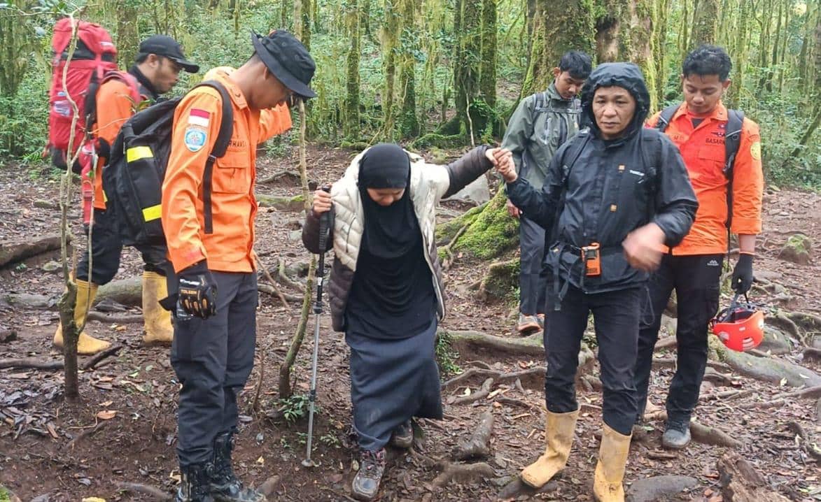 Tim SAR gabungan membantu seorang pendaki wanita yang cedera saat evakuasi di hutan Gunung Bulubaria dengan kondisi medan licin dan berlumpur.