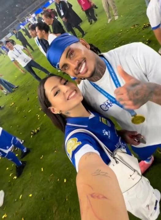 Seorang pemain Persib Bandung berfoto selfie bersama pasangannya di lapangan setelah tim meraih gelar juara.