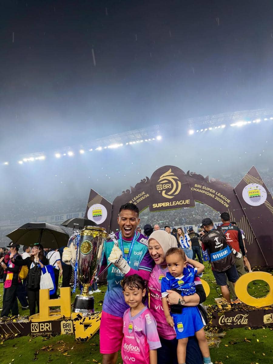 Pemain Persib Bandung merayakan kemenangan bersama keluarga di stadion sambil memegang trofi juara BRI Liga 1 musim 2023–2024.