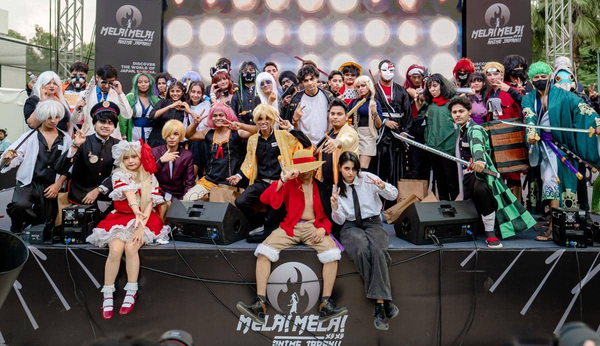 Sekelompok peserta cosplay berpose di atas panggung acara Mela! Mela! Anime Japan!! 2025 di India dengan berbagai kostum karakter anime populer.