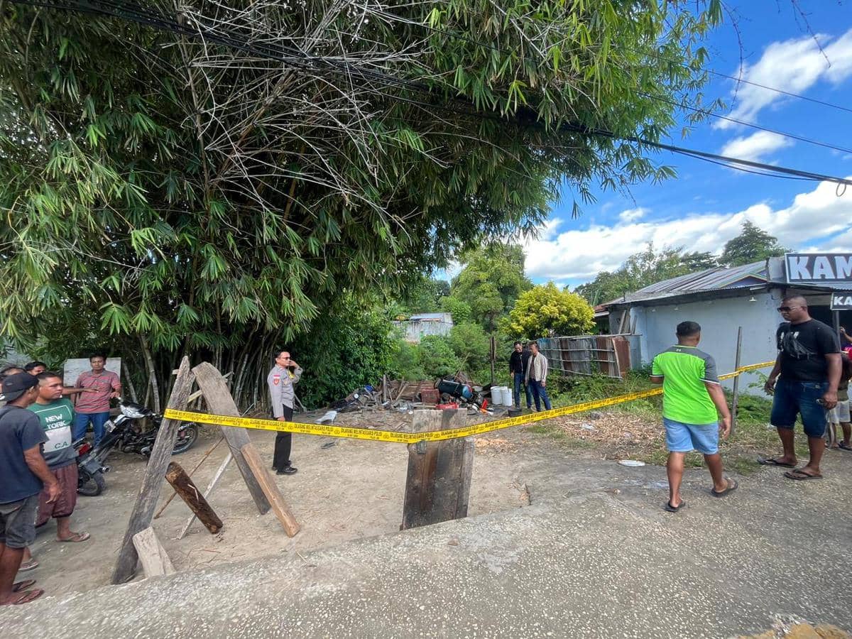 Petugas polisi dan warga berada di lokasi bengkel di Sumba Timur yang dipasangi garis polisi setelah insiden mobil dinas menabrak area tersebut.