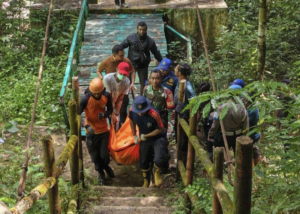 Tim SAR gabungan mengevakuasi seorang warga negara asing menggunakan tandu oranye di jalur hutan menuju Air Terjun Cunca Wulang.