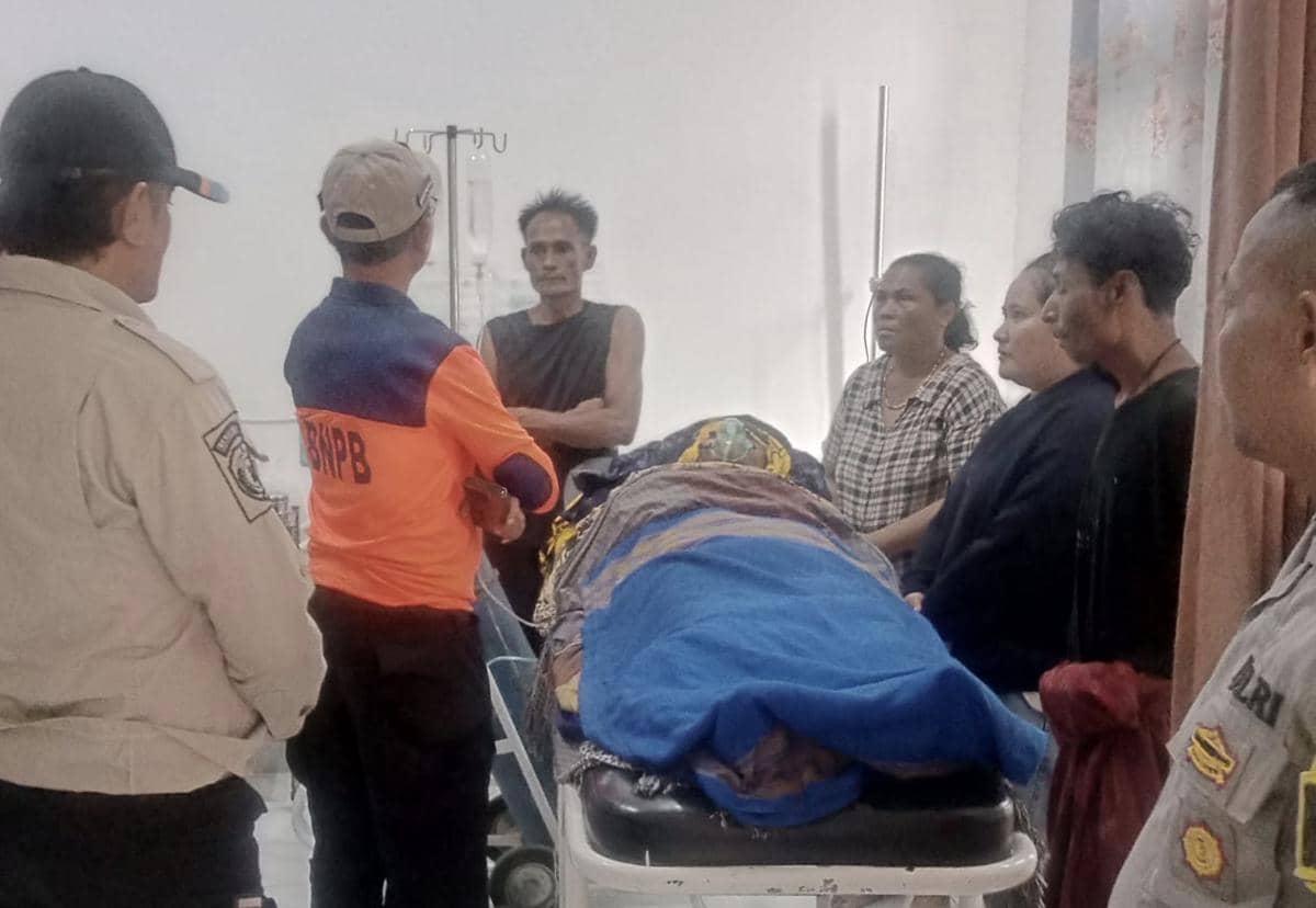 Petugas Basarnas dan keluarga berdiri di sekitar jenazah nelayan yang menjadi korban kapal terbalik di Sabu di ruang rumah sakit.