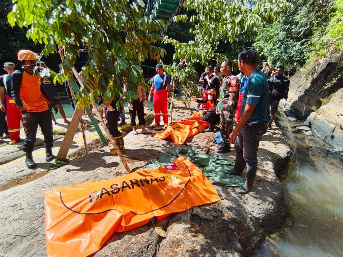 Tim SAR gabungan mengevakuasi korban WNA Austria di area Air Terjun Cunca Wulang dengan kantong jenazah berwarna oranye bertuliskan Basarnas.
