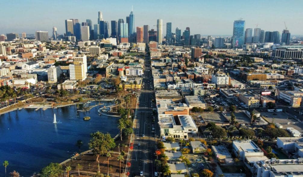 Pemandangan udara kota Los Angeles dengan gedung pencakar langit di pusat kota dan danau di sisi kiri jalan utama.