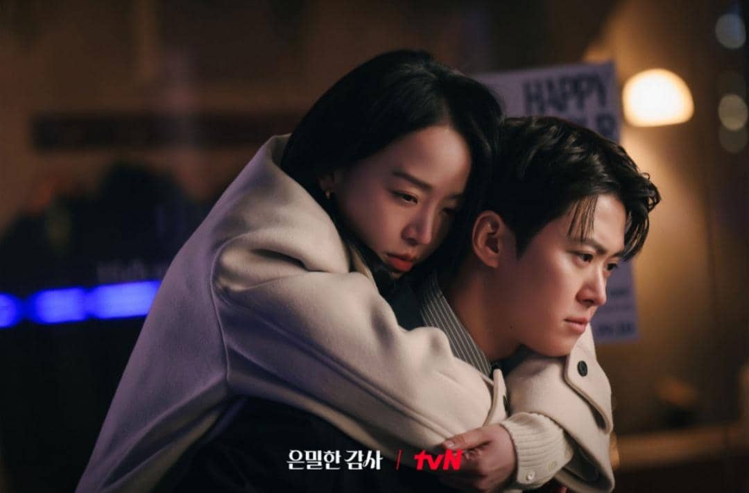 Dua karakter dalam drama Korea Filing for Love berpelukan dengan ekspresi emosional di suasana malam yang hangat.