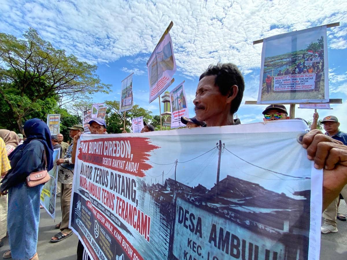 Sejumlah warga Desa Ambulu di Cirebon membawa spanduk dan poster saat berunjuk rasa di depan Kantor Bupati menuntut solusi banjir rob.