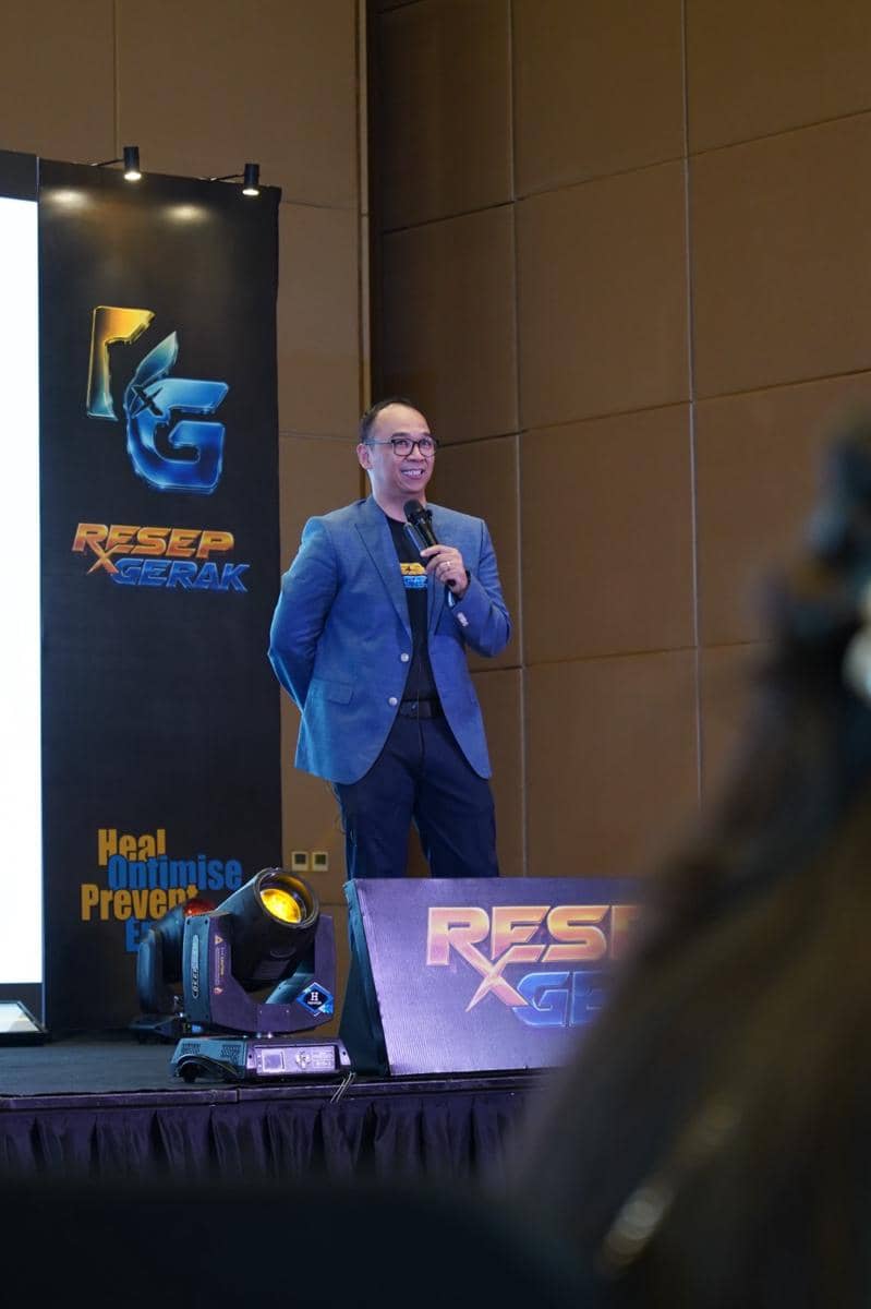 Seorang pria mengenakan jas biru berbicara di atas panggung saat peluncuran resmi platform Resep Gerak ID.