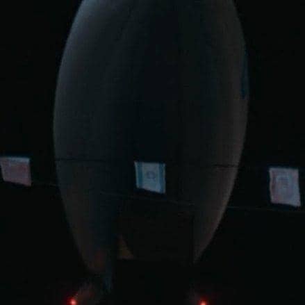 Balon udara besar berwarna gelap melayang di malam hari dengan lampu merah di bawahnya dalam cuplikan drama The WONDERfools.