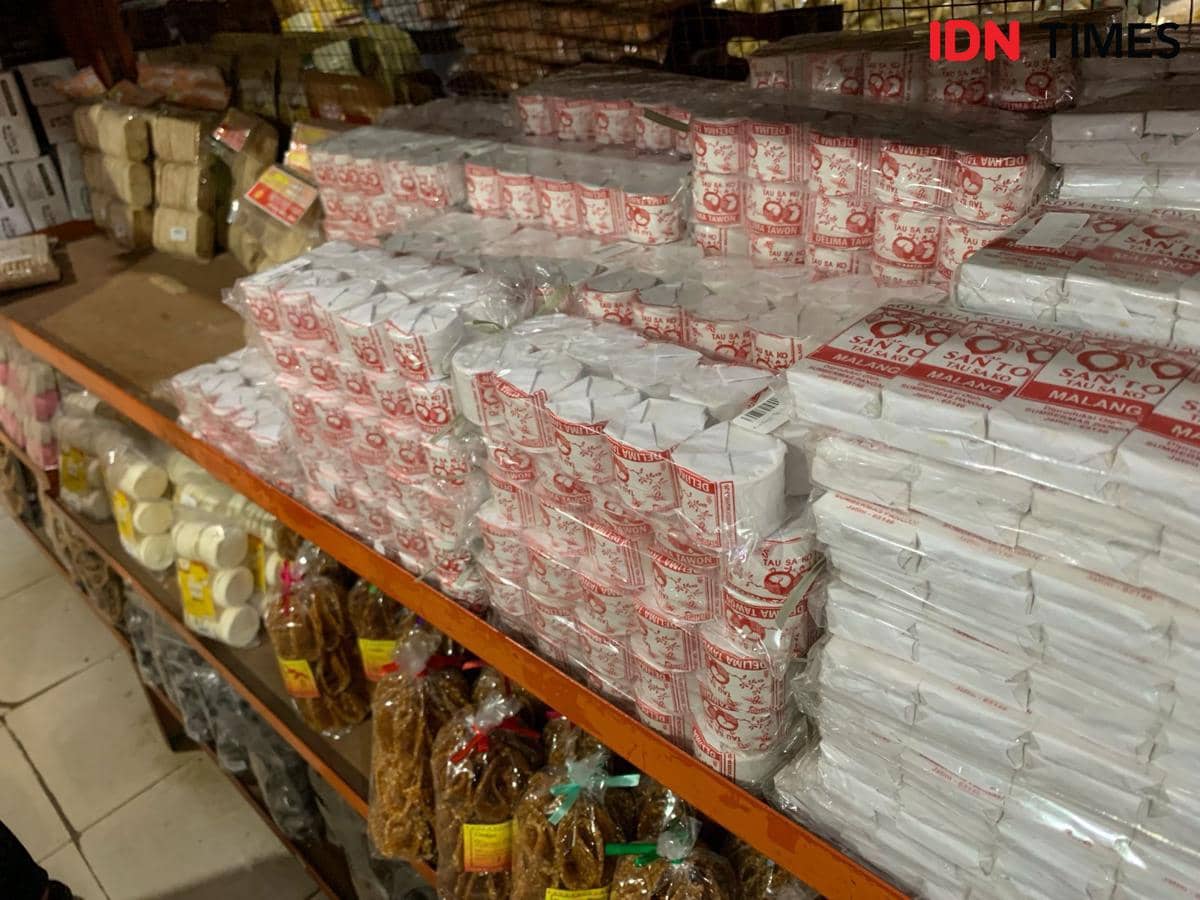 Tumpukan berbagai jenis kerupuk tradisional dalam kemasan plastik tersusun rapi di rak toko oleh-oleh di Tangerang.