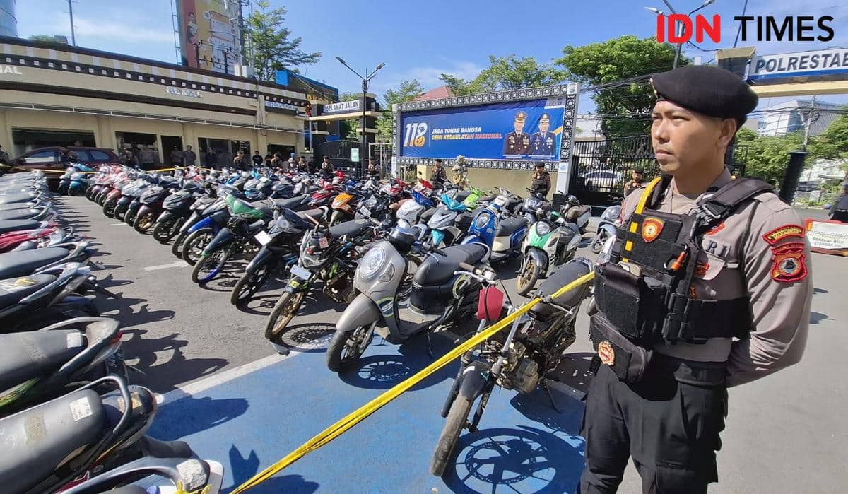 Seorang polisi berjaga di depan deretan sepeda motor hasil sitaan pelaku kejahatan jalanan yang diparkir di halaman Polrestabes Makassar.
