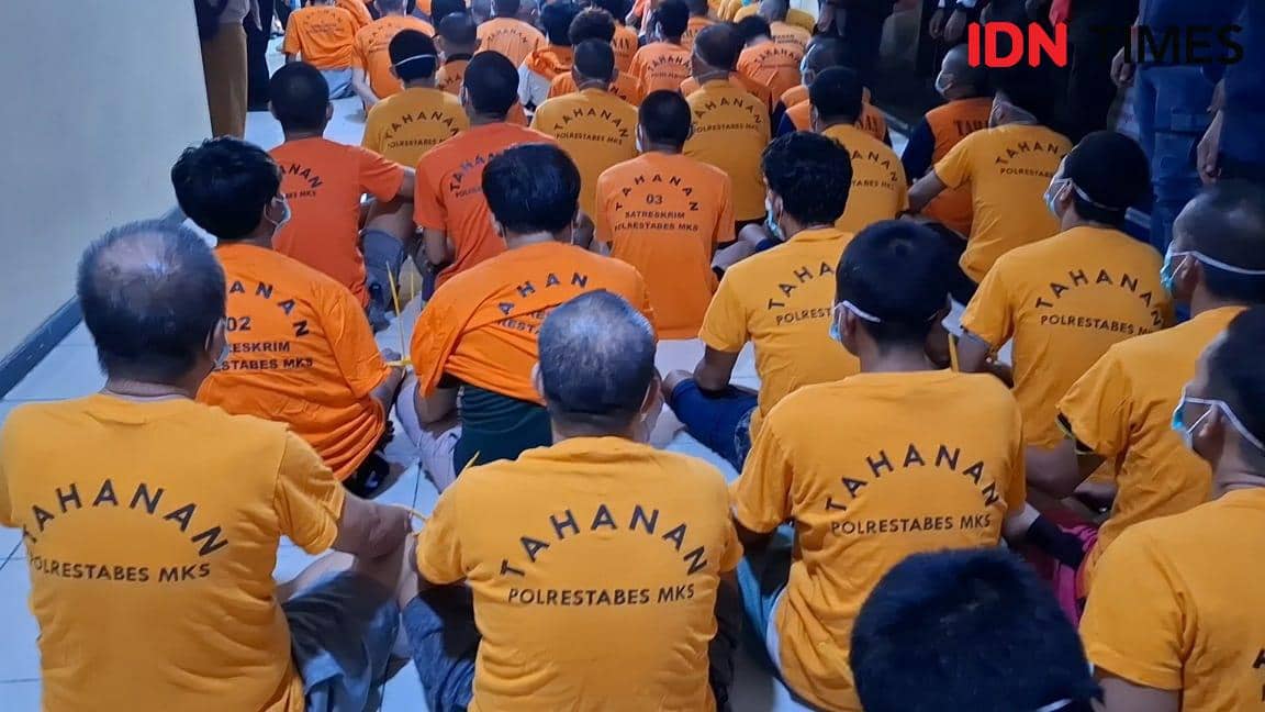 Sejumlah tahanan mengenakan baju oranye bertuliskan 'Tahanan Polrestabes MKS' duduk berbaris di dalam ruangan Polrestabes Makassar.
