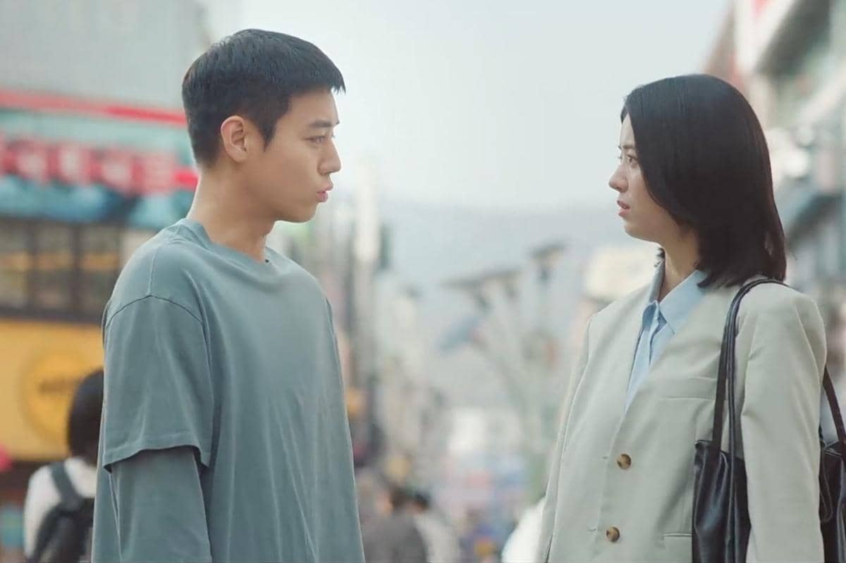 Dua karakter dalam drama The Legend of Kitchen Soldier berdiri saling berhadapan di jalan kota dengan ekspresi serius.