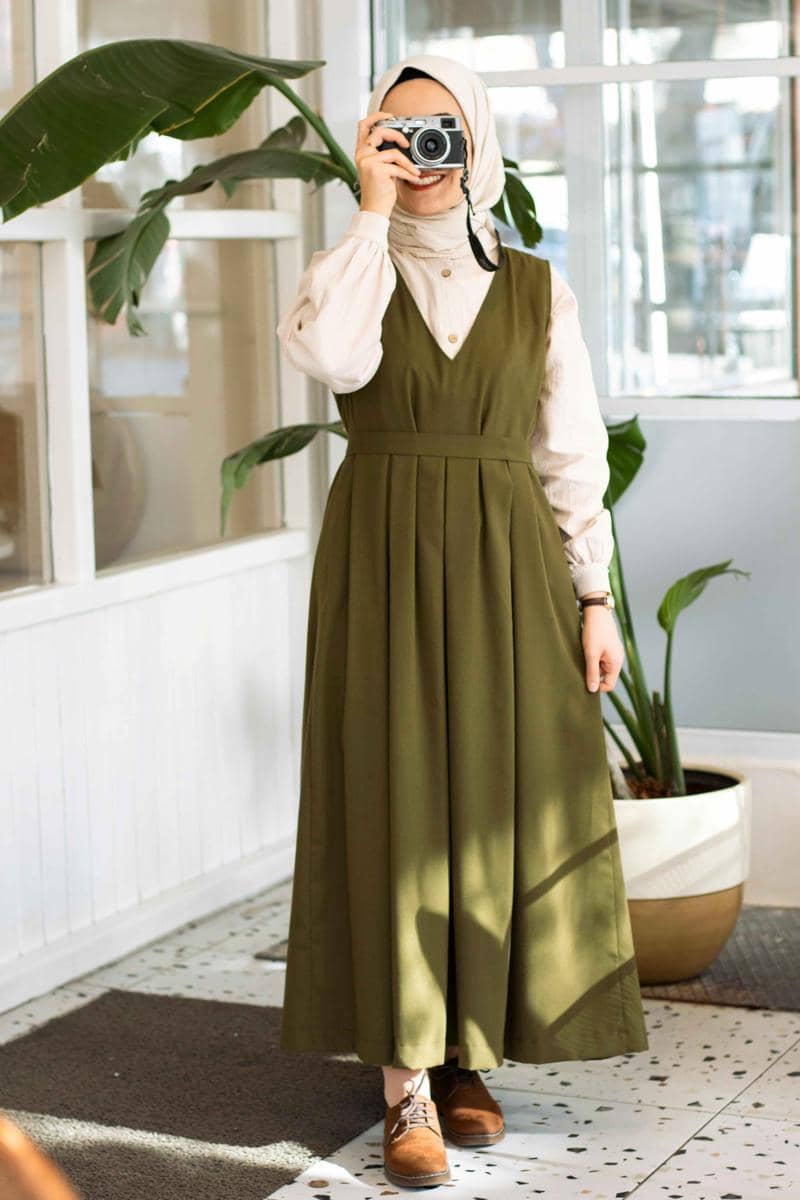 ilustrasi perempuan berhijab menggunakan jumper dress warna hijau