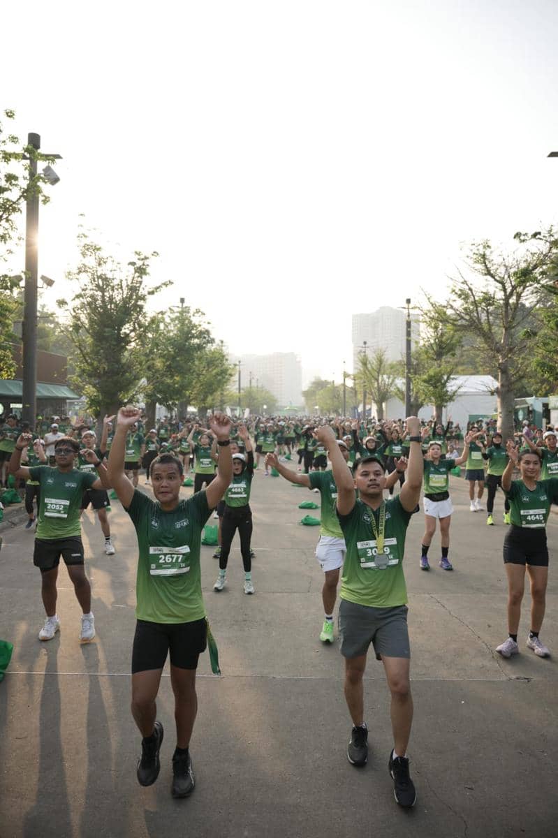 Peserta Starbucks Run 2026 di Jakarta mengenakan kaus hijau melakukan pemanasan bersama di area terbuka sebelum lomba dimulai.