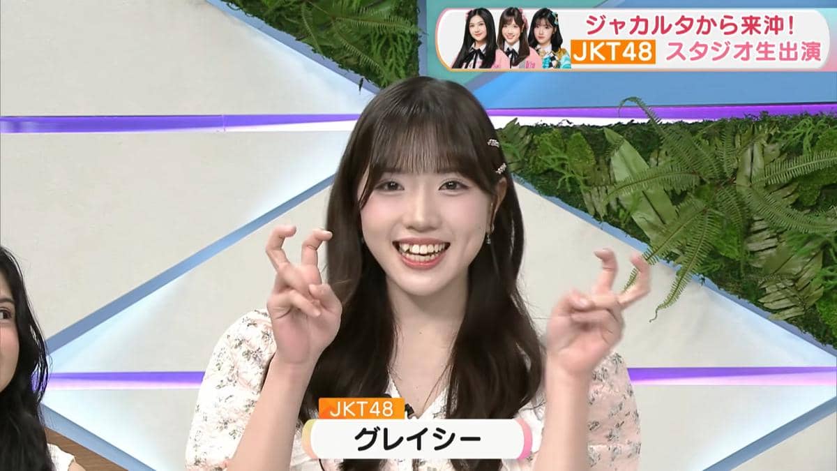 Seorang anggota JKT48 tersenyum sambil mengangkat kedua tangannya dengan pose lucu di acara TV Jepang CATCHY.