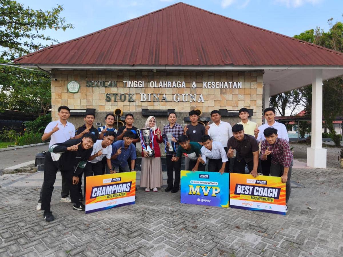 Tim STOK Bina Guna berpose bersama piala dan papan penghargaan Champions, MVP, dan Best Coach di depan gedung kampus mereka.