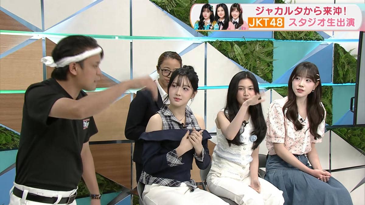 Tiga anggota JKT48 duduk di studio acara TV Jepang CATCHY bersama dua pembawa acara yang sedang berbincang.
