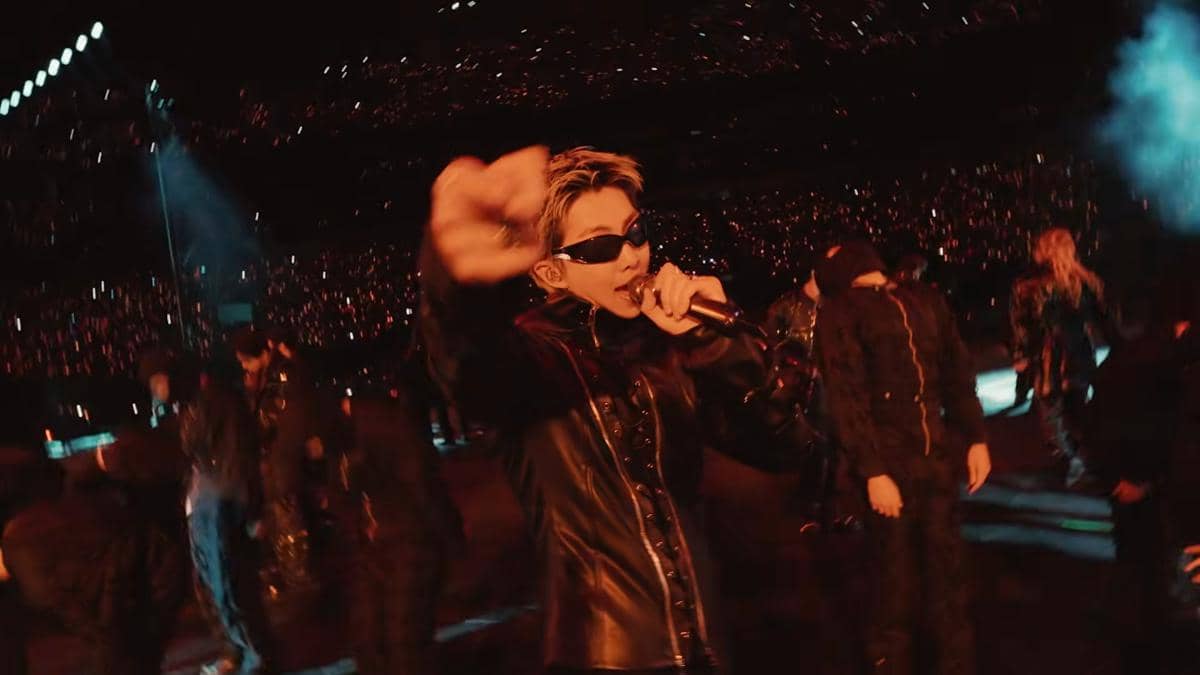 Penampilan grup musik BTS di panggung American Music Awards 2026 dengan pencahayaan merah dan suasana konser yang meriah.