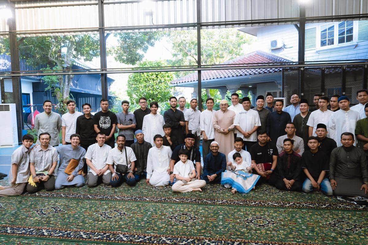 Sekelompok orang mengenakan busana muslim berfoto bersama di sebuah ruangan luas dengan karpet hijau saat perayaan Idul Adha 2026.