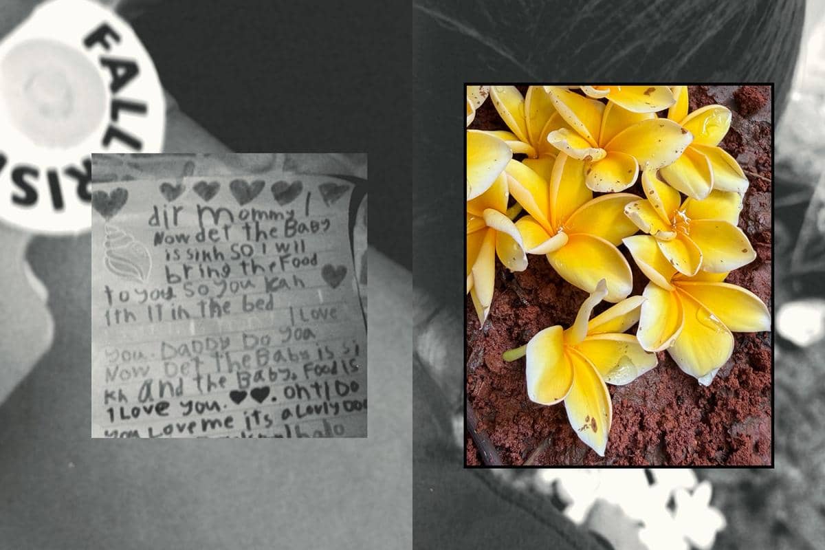 Surat tulisan tangan anak dengan gambar hati di kertas dan bunga kamboja kuning di atas tanah merah di area makam.