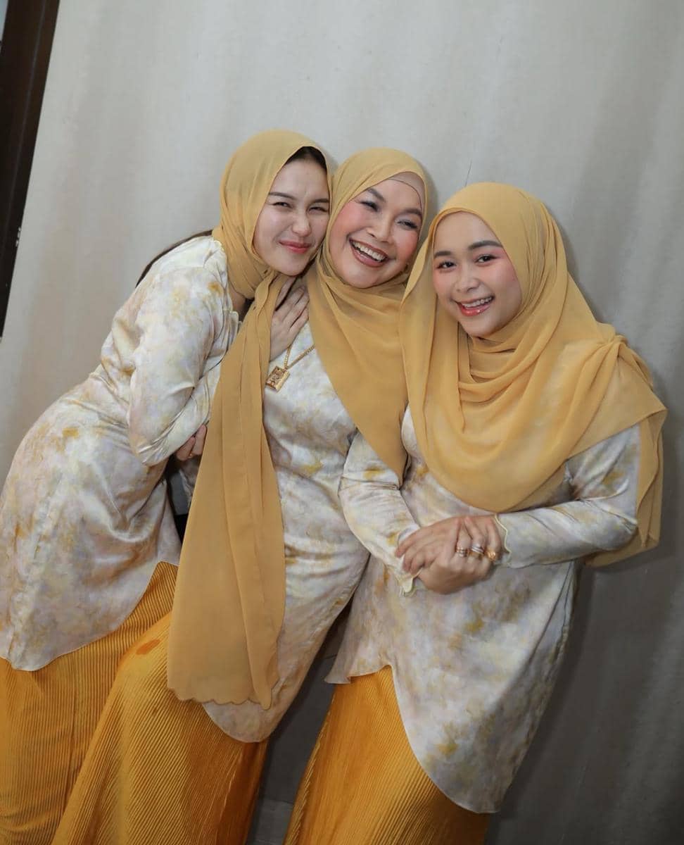 Tiga perempuan mengenakan hijab kuning dan busana senada berwarna krem serta kuning, tersenyum bersama di momen Idul Adha 2026.