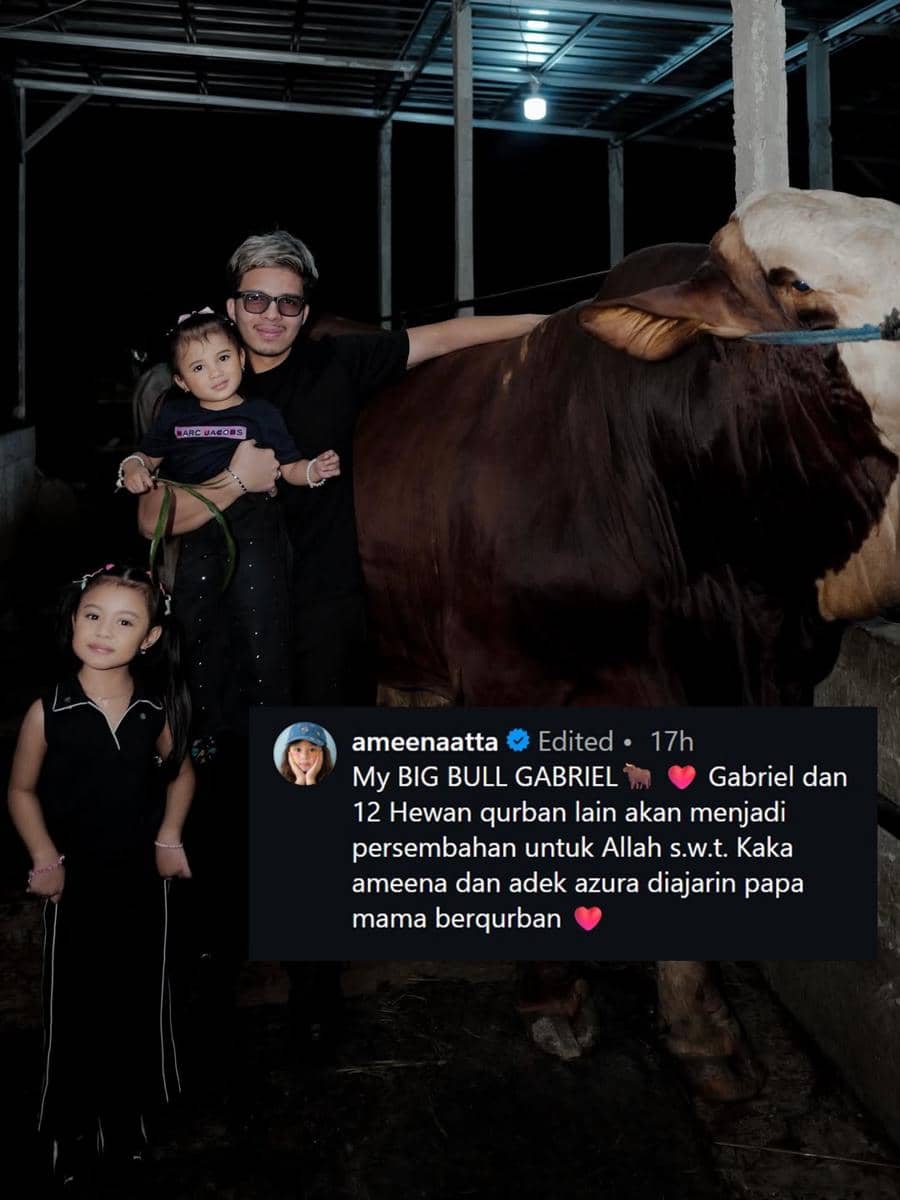 Seorang pria bersama dua anak kecil berpose di kandang sapi besar pada malam hari menjelang perayaan kurban 2026.