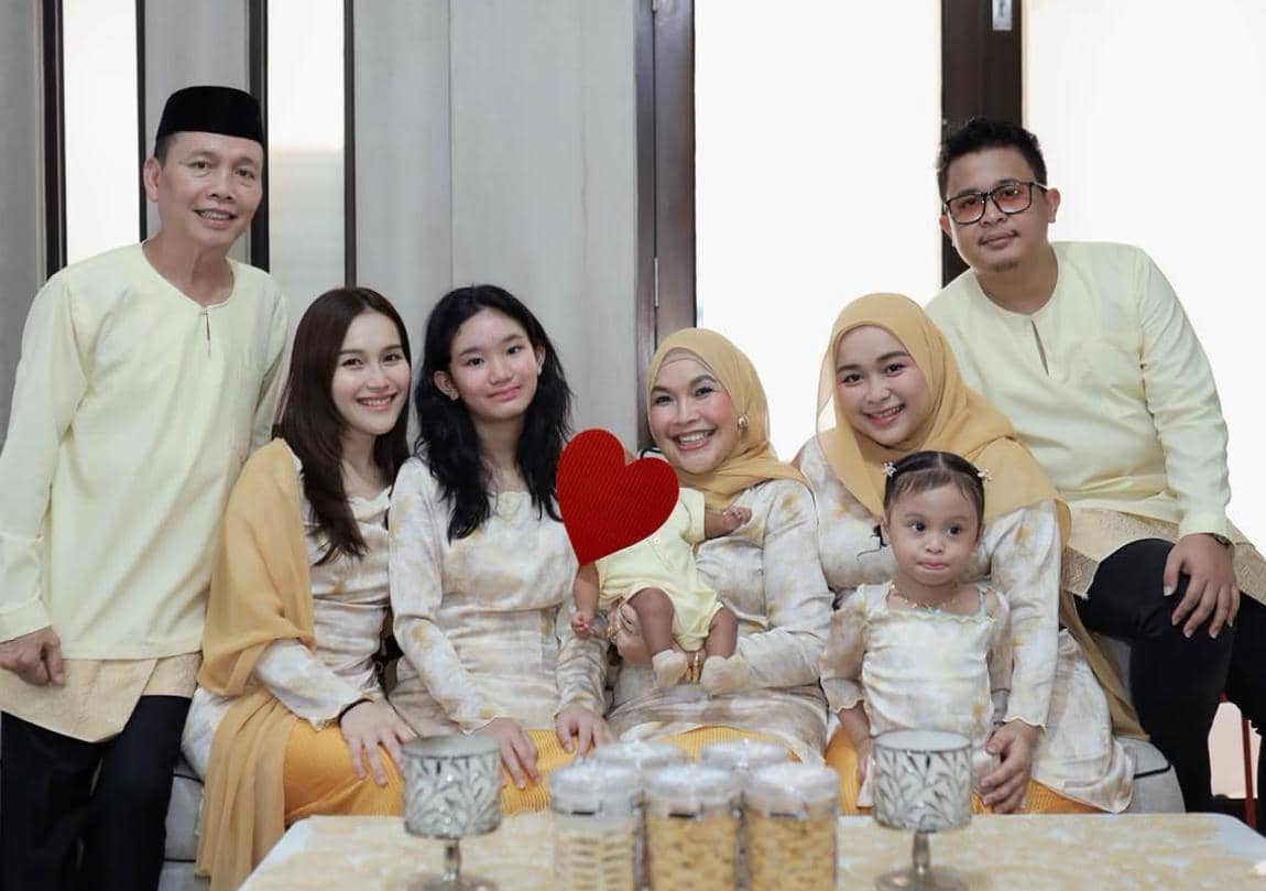 Sebuah keluarga berpose bersama di ruang tamu mengenakan busana seragam warna krem dan kuning saat perayaan Idul Adha 2026.