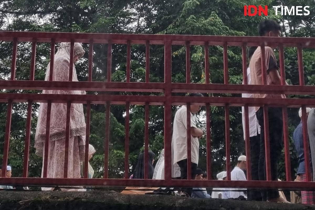 Potret jemaah di pagar pembatas Jembatan Ampera (IDN Times/Rangga Erfizal)