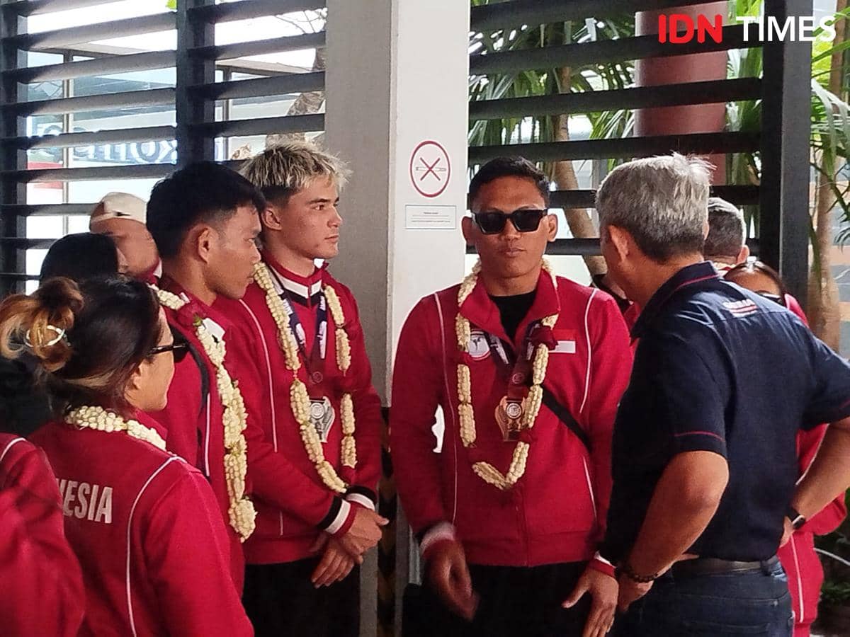 Para atlet Timnas MMA Indonesia mengenakan jaket merah dan kalung bunga setelah tampil di Kejuaraan Asia MMA 2026.