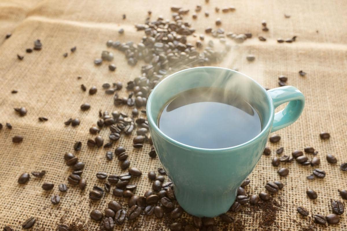 ilustrasi secangkir kopi hitam dari biji kopi lokal
