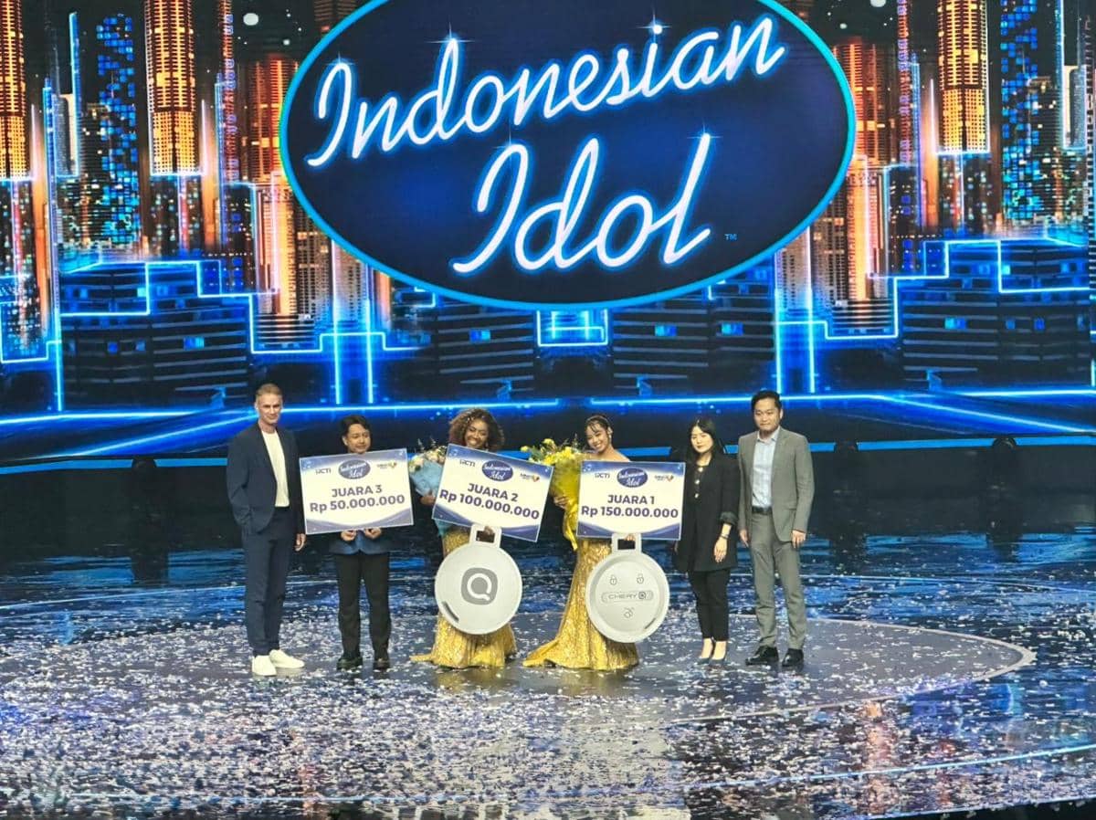 Para pemenang Indonesian Idol berpose di panggung dengan papan hadiah uang tunai dan simbol hadiah mobil Chery Q di acara final.