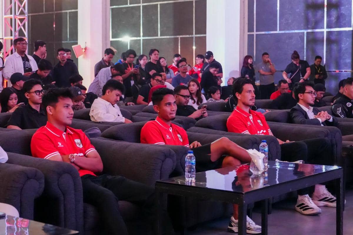 Para pemain Timnas Indonesia mengenakan seragam merah duduk di kursi acara peluncuran EA Sports FC dengan suasana ramai di ruangan.