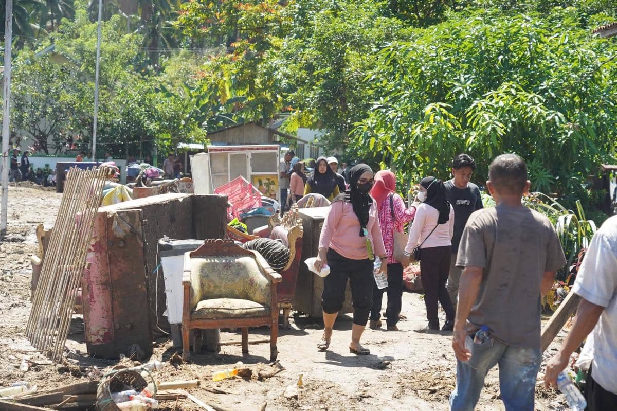 Warga membersihkan dan mengevakuasi barang-barang rumah tangga yang rusak akibat banjir di Kecamatan Bolaang, Kabupaten Bolmong.