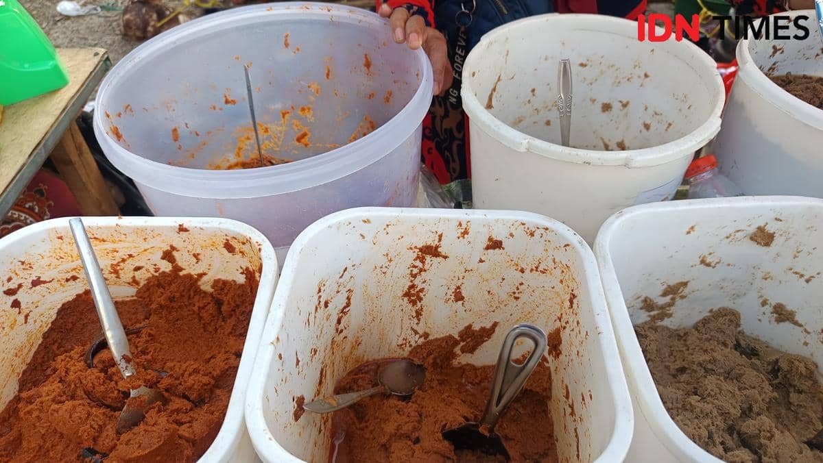 Berbagai jenis bumbu racik matang dalam wadah plastik besar dengan sendok logam dijual di Pasar Pabaeng-baeng, Makassar.