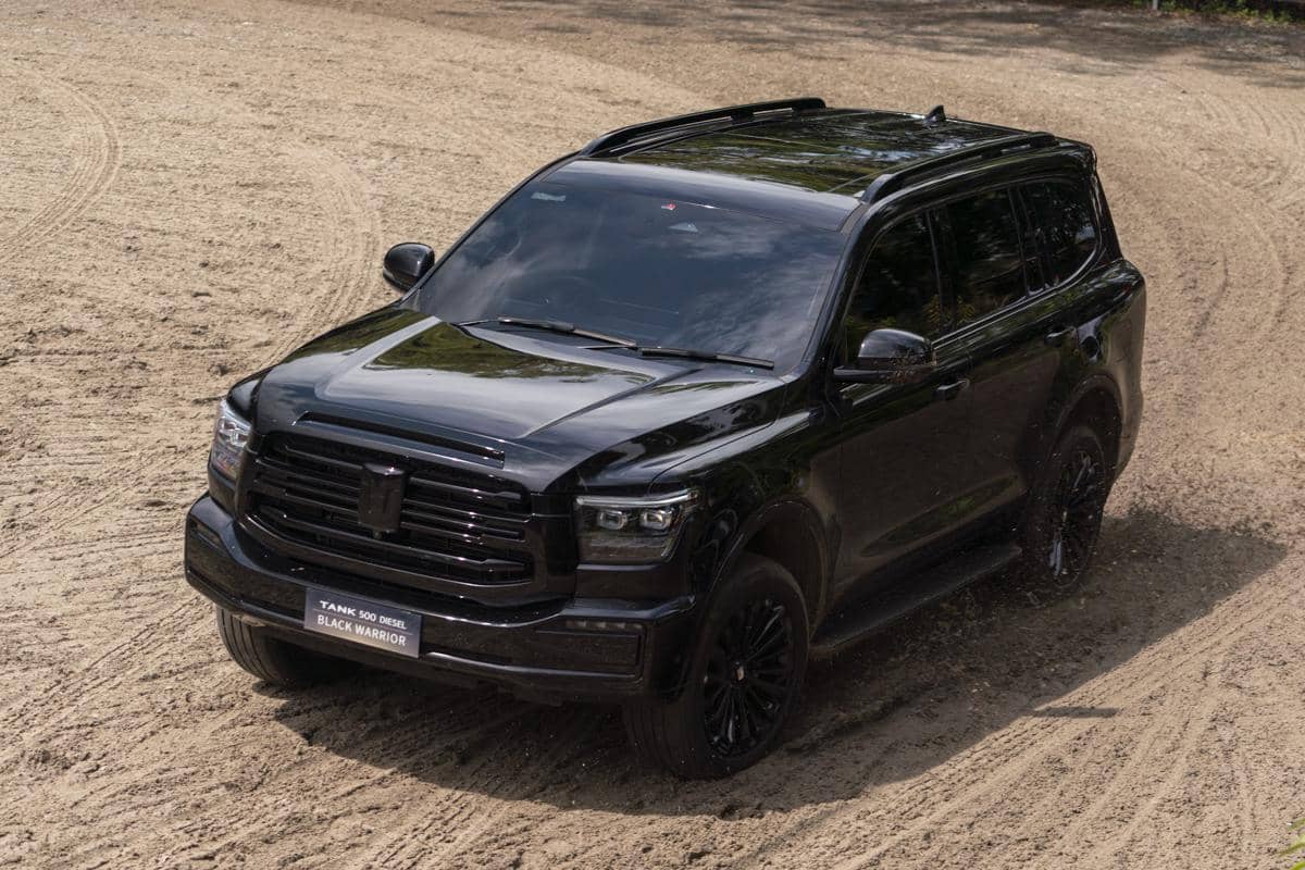 SUV hitam GWM Tank 500 Diesel Black Warrior melaju di jalur tanah dengan desain gagah dan kemampuan off-road tangguh.