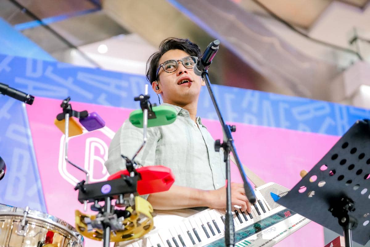 Seorang musisi memainkan keytar dan bernyanyi di atas panggung dengan latar berwarna cerah pada acara BeautyFest Asia Jakarta 2026.