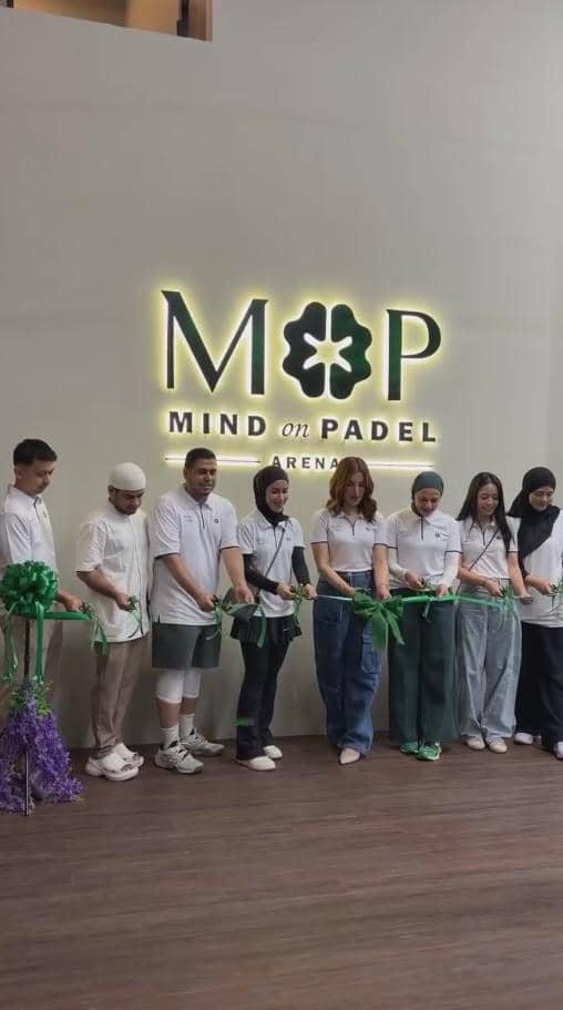 Beberapa orang berdiri berjajar mengenakan pakaian kasual putih dan memotong pita hijau di depan logo Mind on Padel Arena.
