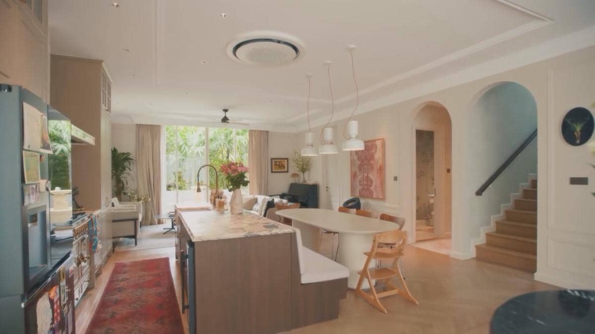 Ruang makan dan dapur rumah mewah dengan desain modern minimalis, pencahayaan alami, serta dekorasi bunga di meja marmer.