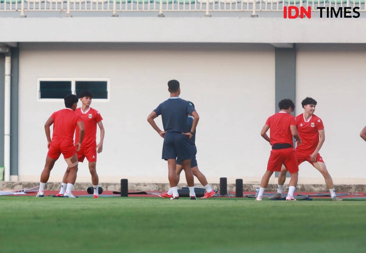 Pemain Timnas Indonesia U-19 mengenakan seragam merah berlatih di Stadion Madya Sumut bersama pelatih di lapangan hijau.