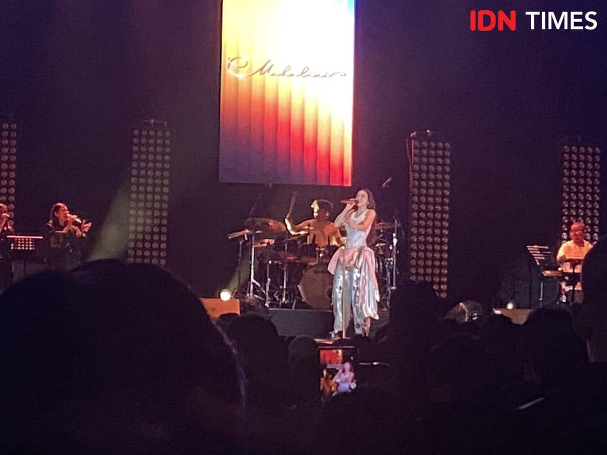 Penyanyi tampil di atas panggung bersama band pengiring dalam konser musik Java Jazz Festival 2026 dengan pencahayaan panggung berwarna hangat.