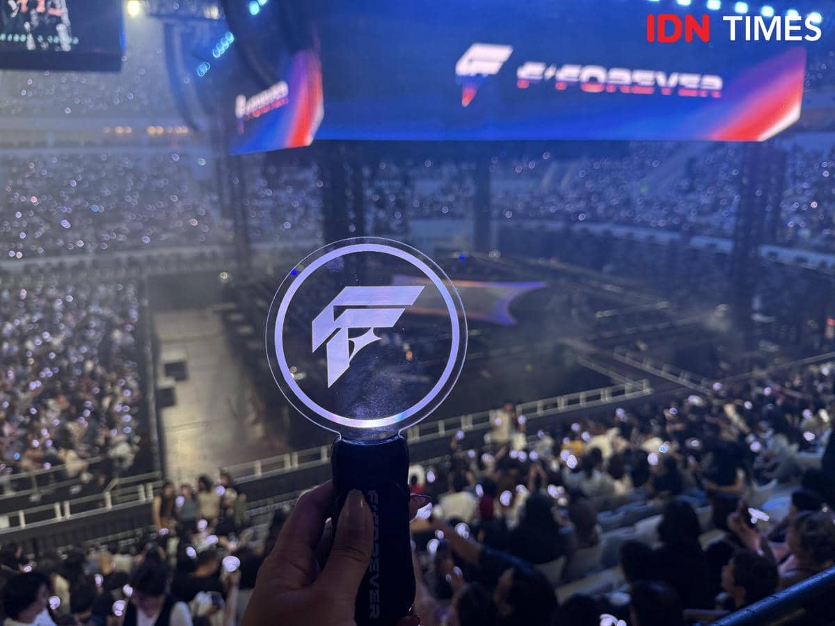 Penonton memenuhi stadion saat konser F-FOREVER, dengan seseorang memegang lightstick bergambar logo F di tengah keramaian.