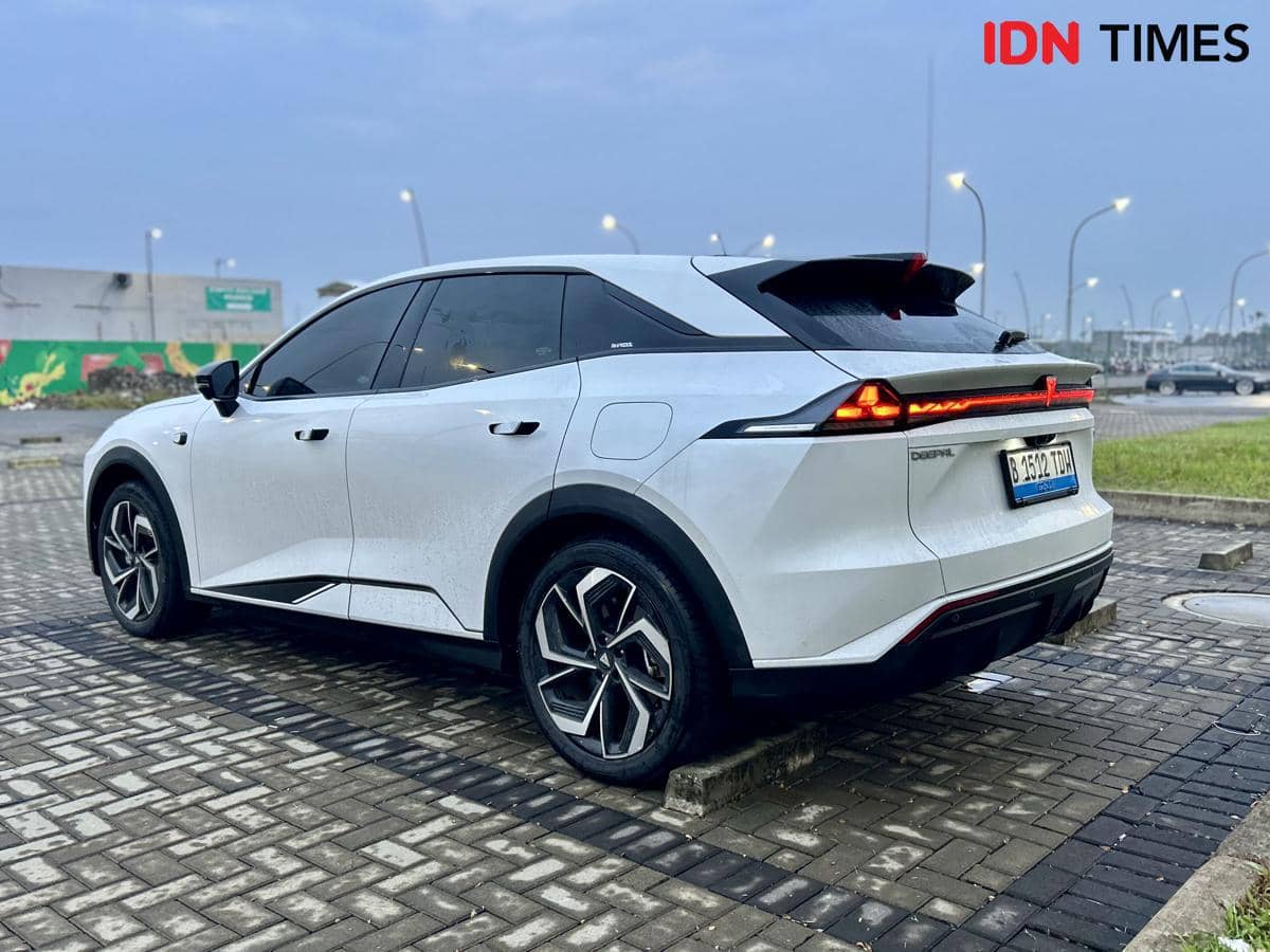 Tampak belakang mobil listrik Deepal S07 berwarna putih dengan desain futuristik di area parkir berlampu pada sore hari.