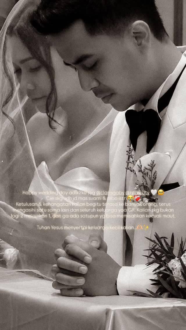 Pasangan pengantin berdoa bersama dalam upacara pernikahan, sang mempelai wanita mengenakan gaun putih dan kerudung tipis.