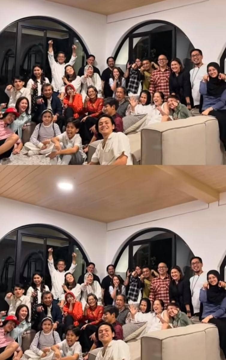 Sekelompok besar orang dari berbagai usia berpose bersama di ruang tamu dengan jendela besar berbentuk lengkung dan suasana hangat.