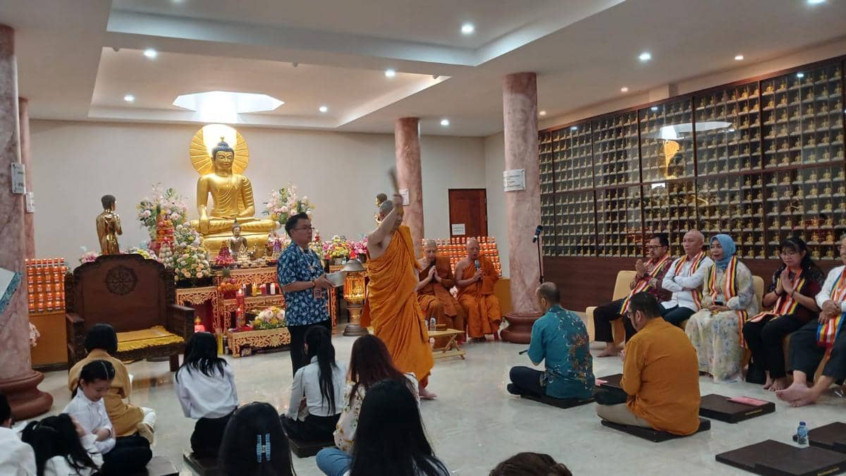 Umat Buddha mengikuti ibadah Tri Suci Waisak di Vihara Dhammadipa Manado dengan biksu memimpin doa di depan altar patung Buddha.