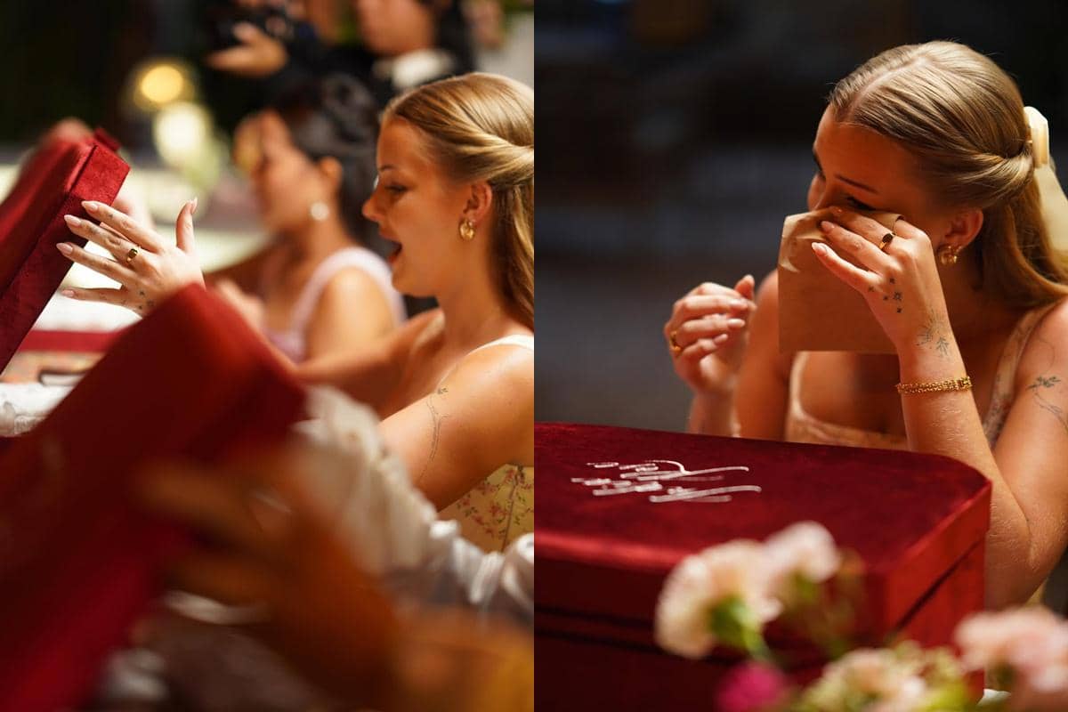Seorang perempuan tersenyum dan terharu saat membuka kotak hadiah berwarna merah beludru dalam acara bridal lunch bersama para bridesmaid.